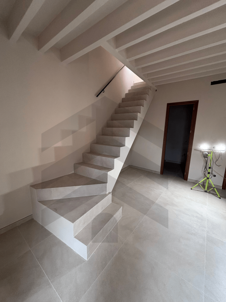 Escalera de obra nueva con acabado moderno en vivienda reformada en Mallorca